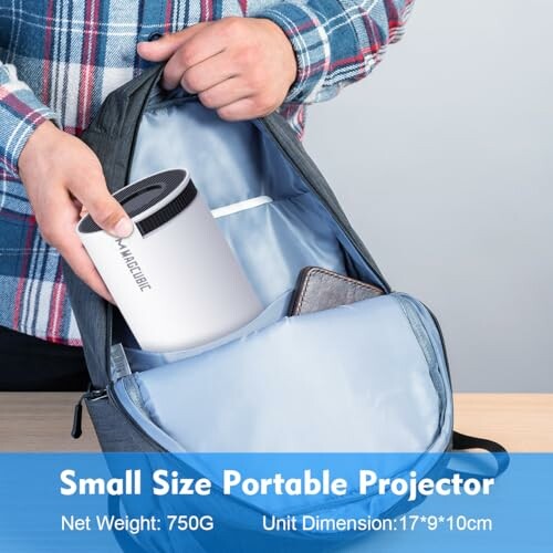 Person placing a small portable projector into a backpack.